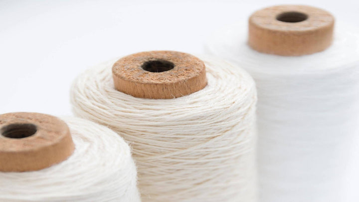 Photo of three spools of white hemp thread. For E1011's page on hemp art.