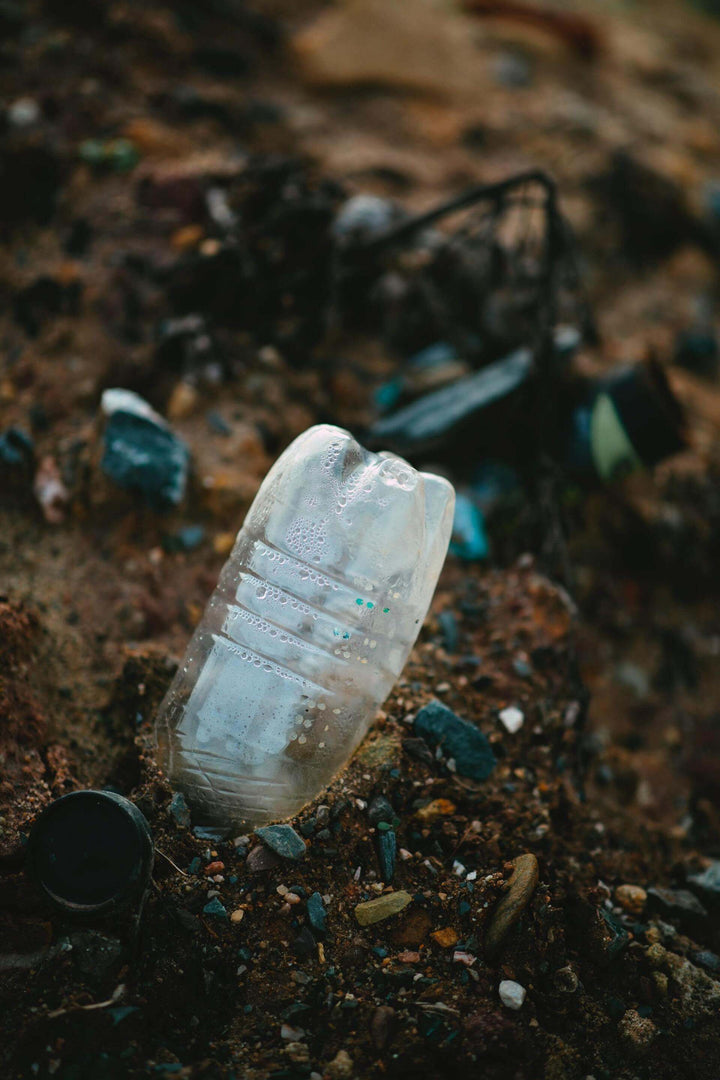 plastic and metal trash in the dirt ground